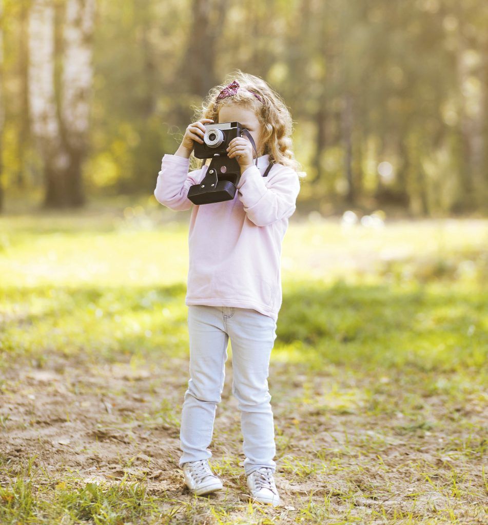 Little girl with retro camera autumn outdoors